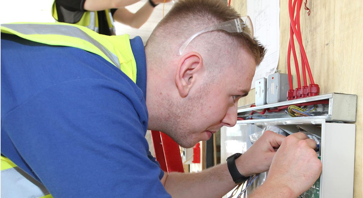 Fire Systems Apprentice working a fire alarm panel